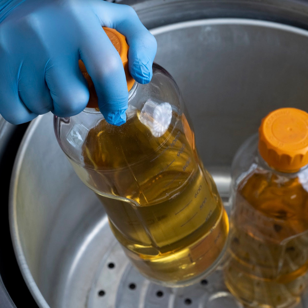 hand placing jar into an All American Sterilizer