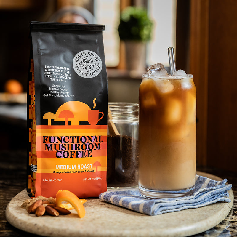 Bag of functional mushroom coffee next to a glass of iced coffee.