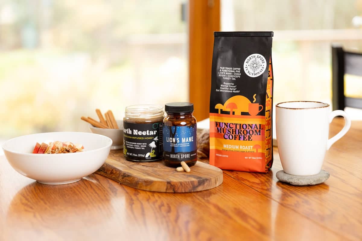 Mushroom Coffee package and mushroom wellness products on a wooden table with a blurred background 